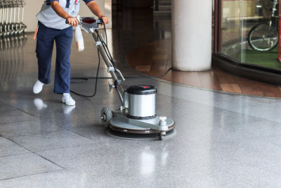 worker cleaning the floor with polishing machine